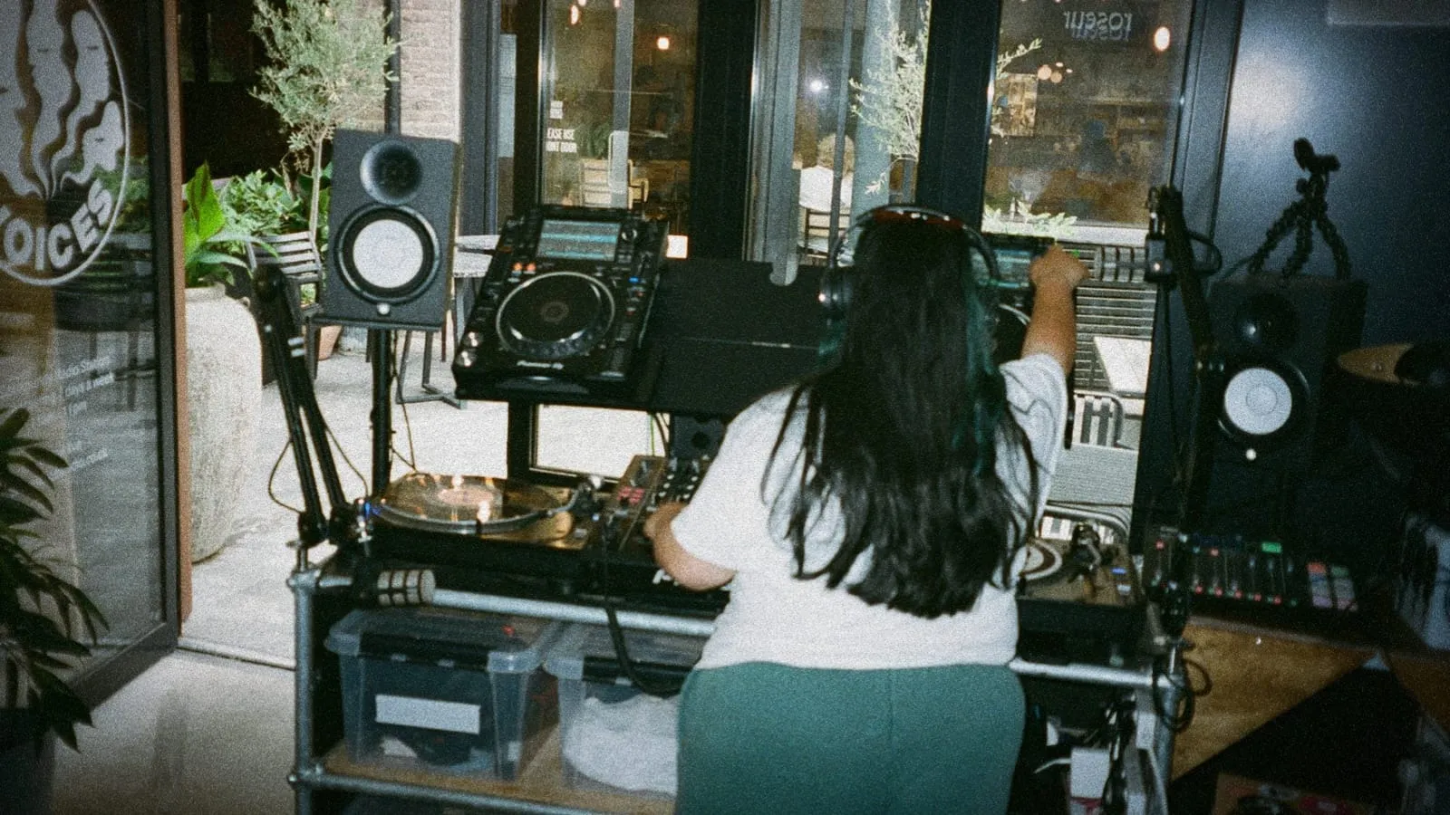 DJ mixing on turntables and CDJs at an outdoor cafe setup